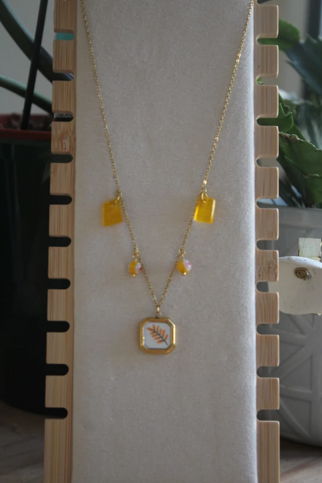 Collier à pampilles jaune et pendentif motif végétal