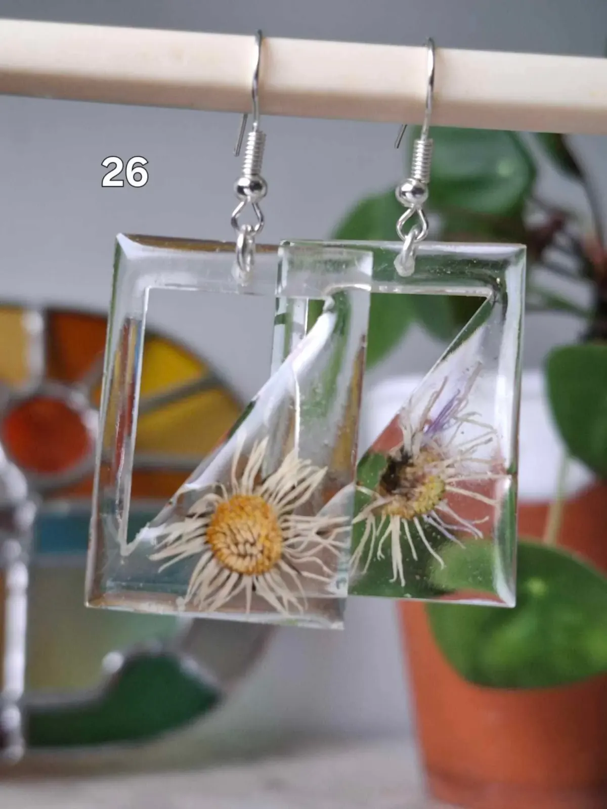 Boucles d'oreilles rectangulaires transparentes en résine avec de véritables fleurs séchées blanches et jaunes.