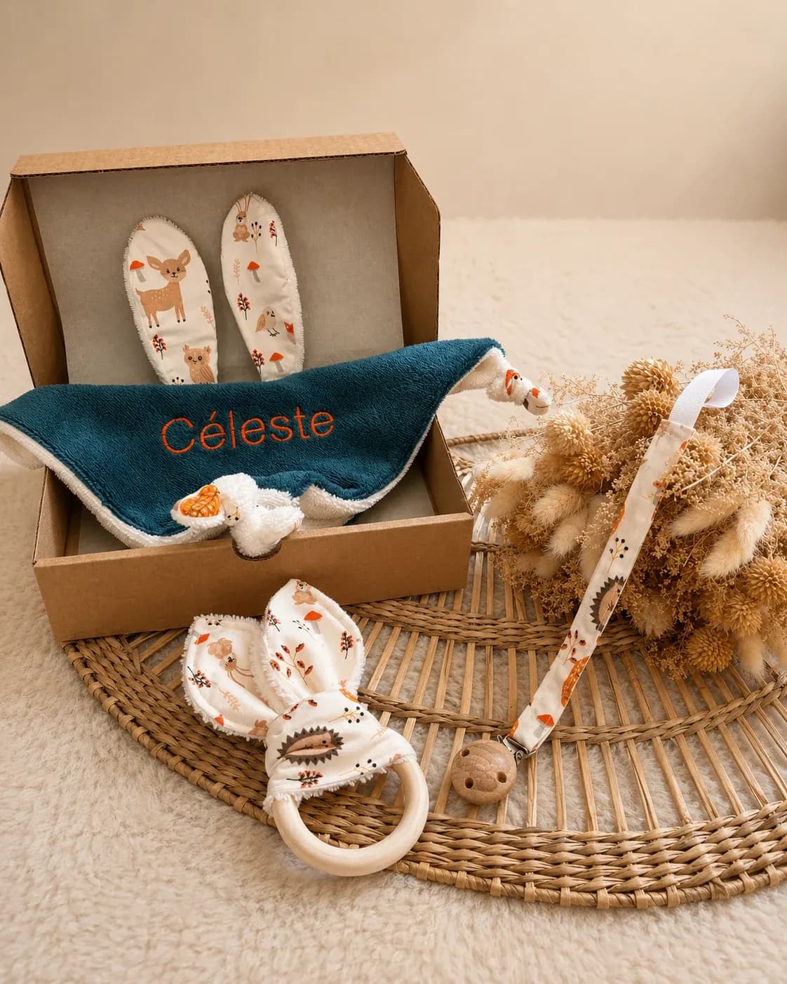 Coffret cadeau en carton contenant le doudou brodé Céleste, l'attache-tétine et l'anneau de dentition.