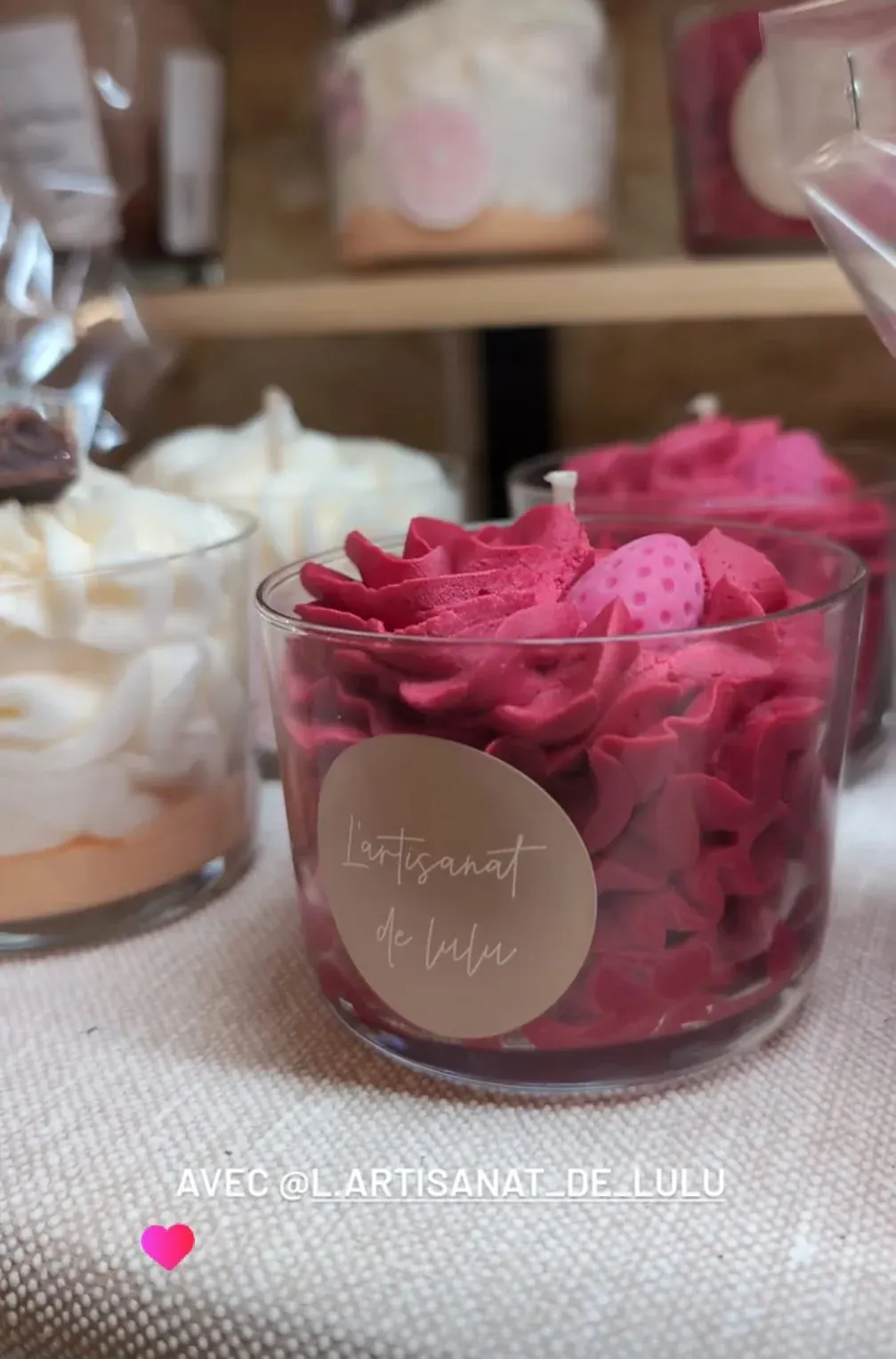 Bougie en récipient transparent avec cire pochée rose fuchsia façon chantilly et décor fraise.