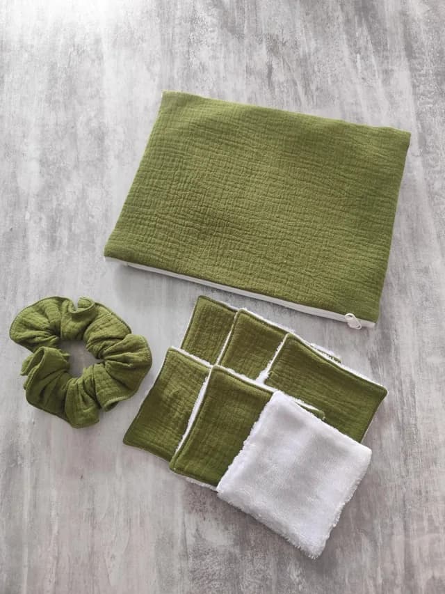 Kit avec pochette zippée vert olive, chouchou assorti et lingettes réutilisables carrées sur fond gris.