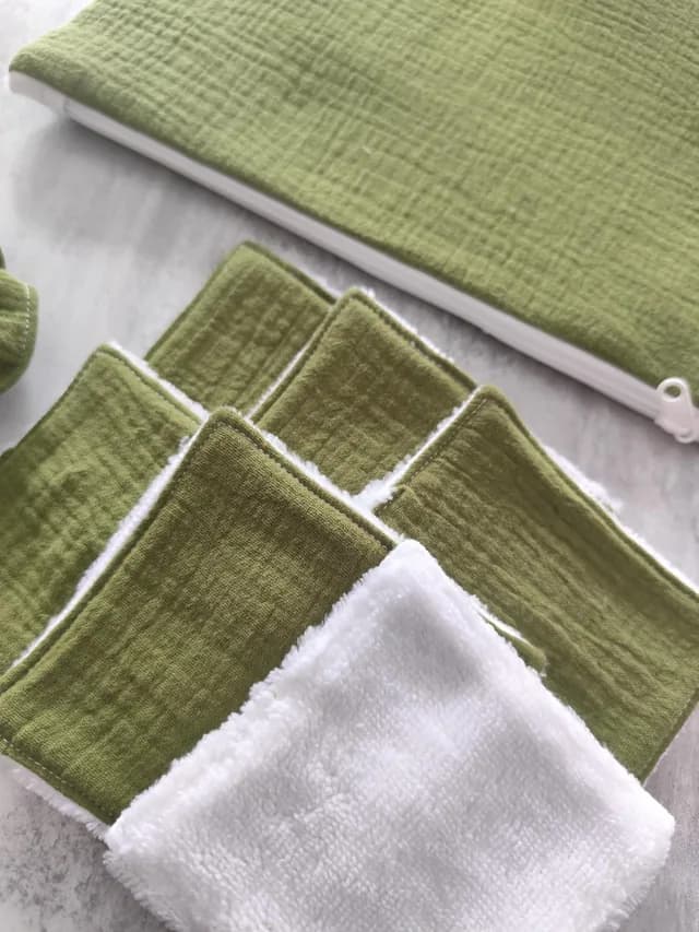 Gros plan sur les lingettes lavables vertes et blanches avec le bord de la pochette zippée.