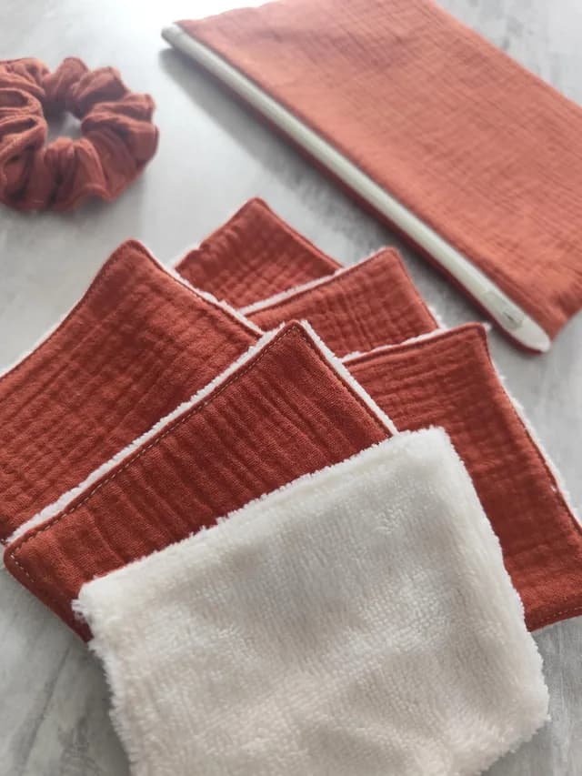 Gros plan sur les lingettes lavables terracotta et blanches avec la pochette et le chouchou